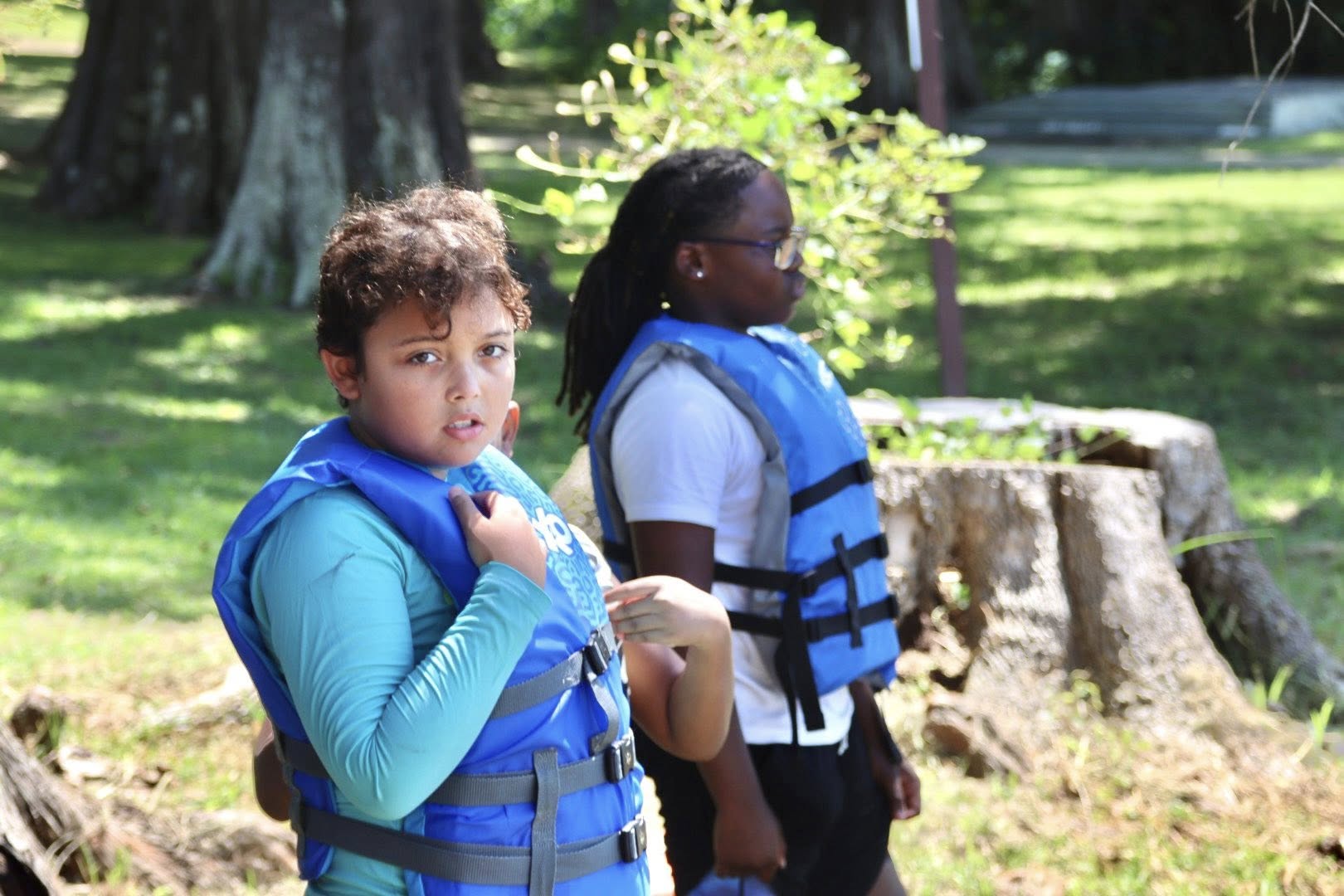 A boy and a girl each wearing a lifejacket.